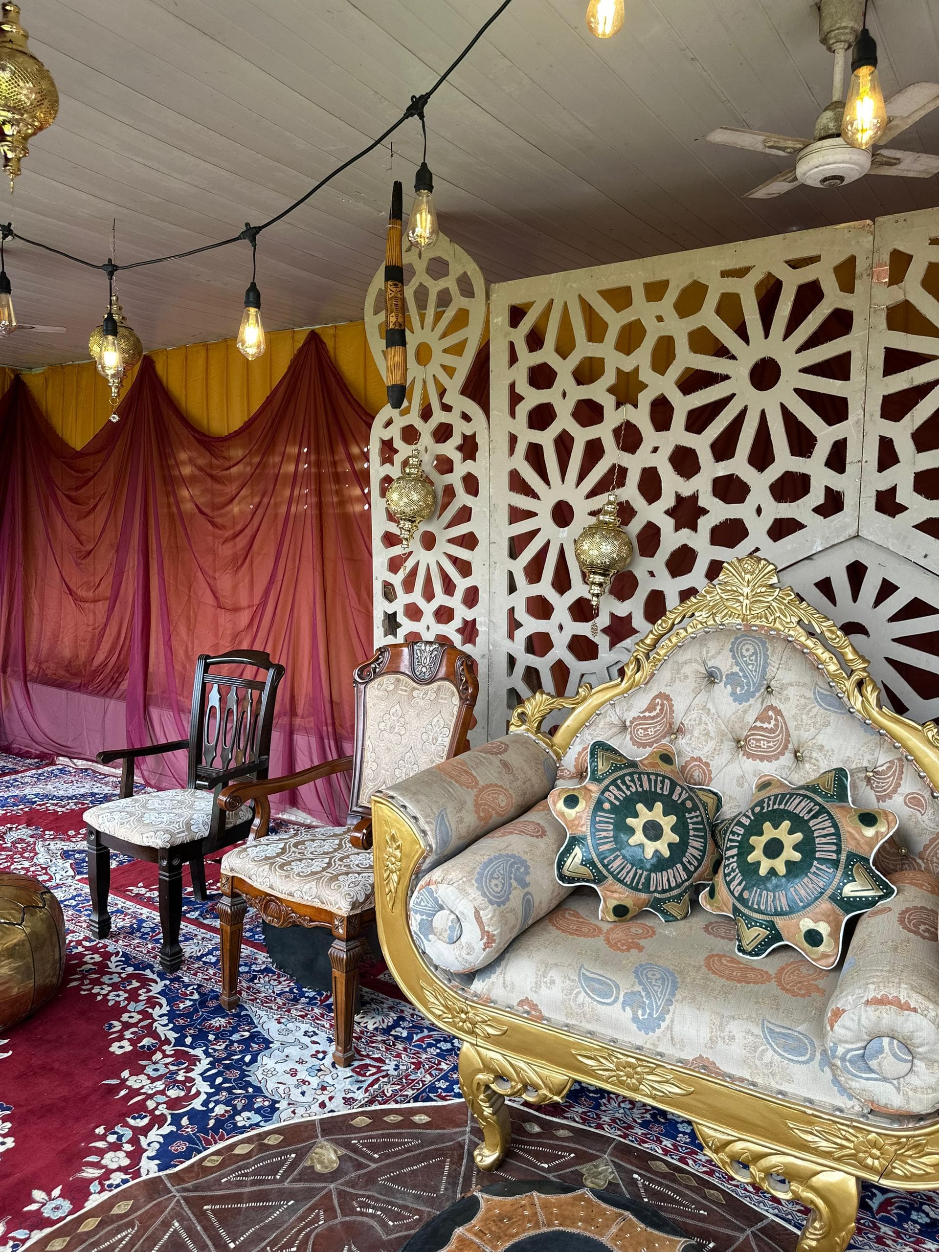 Durbar ceremony Lagos — ceremonial stage with rich jewel-tone fabric and lantern clusters