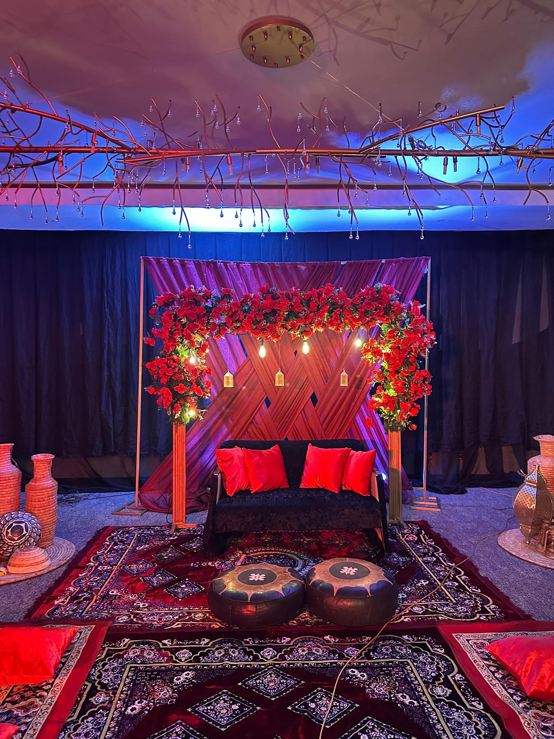 Henna party decoration Lagos — jewel-toned cushions and Moroccan lanterns
